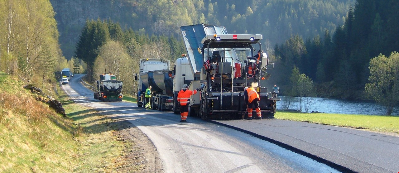 Lastebil og veivals som legger ny asfalt