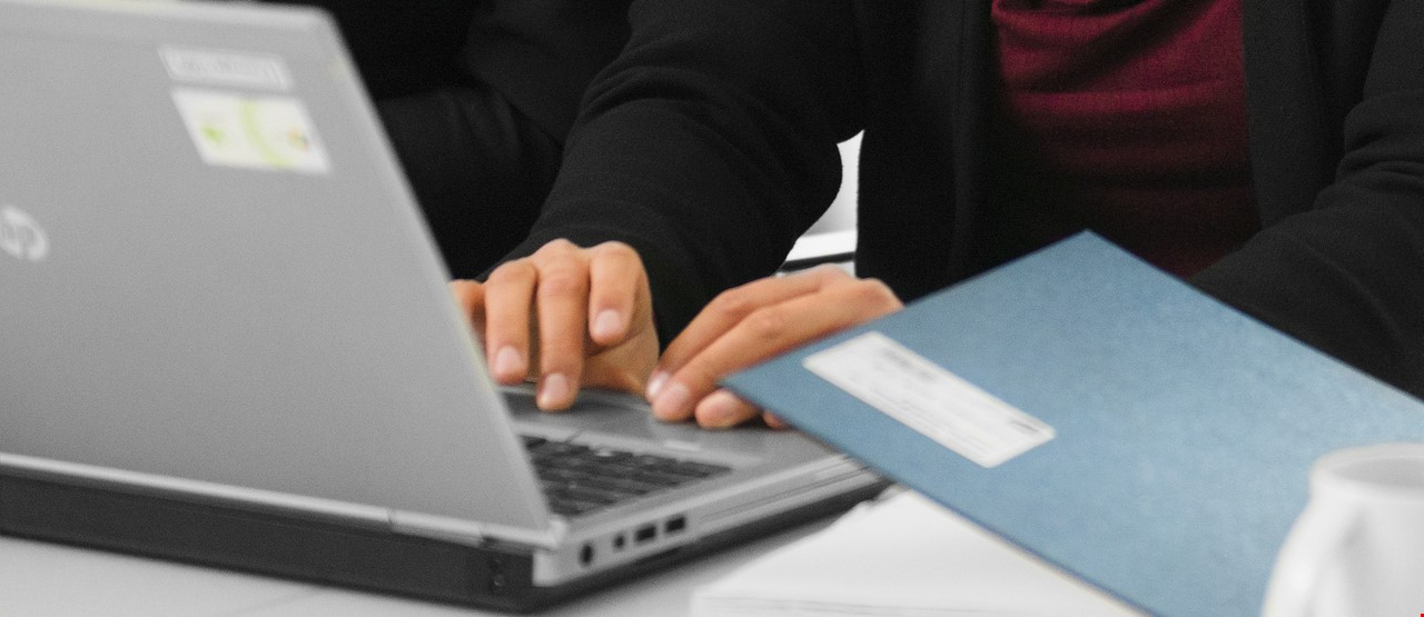 Hender som skriver på en laptop