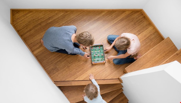3 barn som sitter i på gulvet og spiller bordfotball