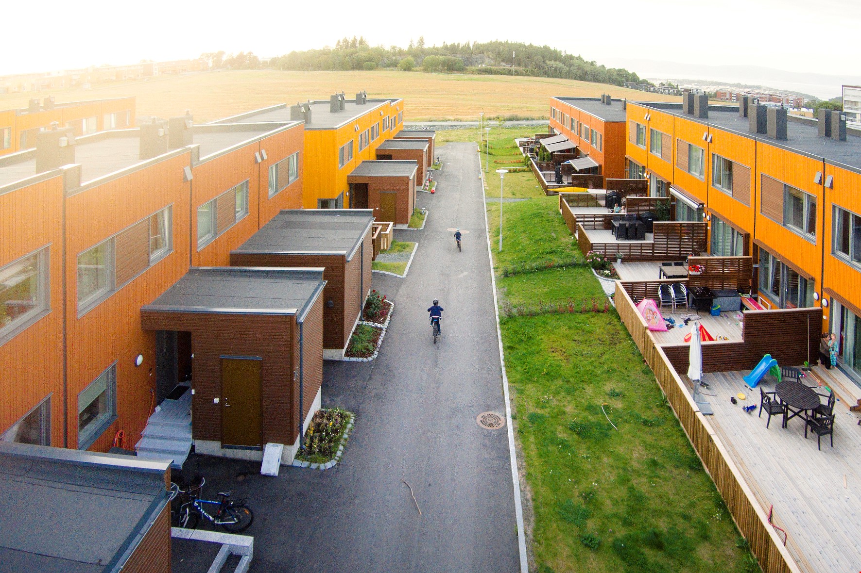 En rekke med moderne, oransje boliger sett fra fugleperspektiv