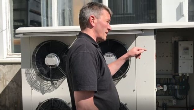 Mann som står foran ventilasjonsanlegg