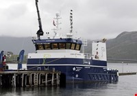 Hvit og blå båt som ligger til kai