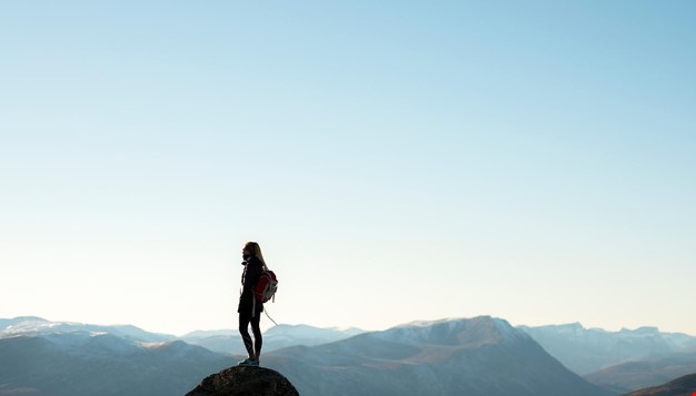 En dame som står på en fjelltopp