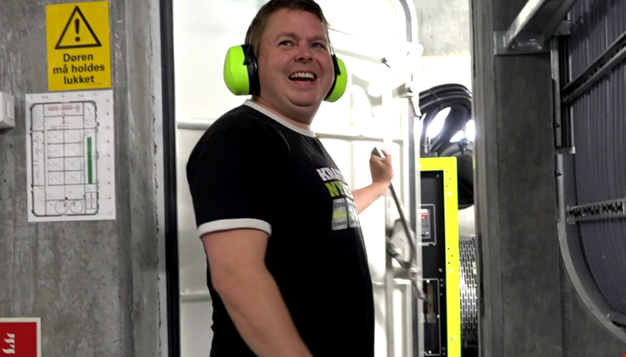 En person inne på et maskinrom som smiler
