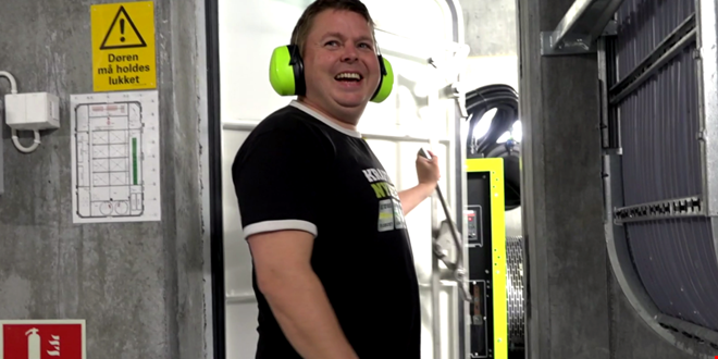 En person inne på et maskinrom og smiler