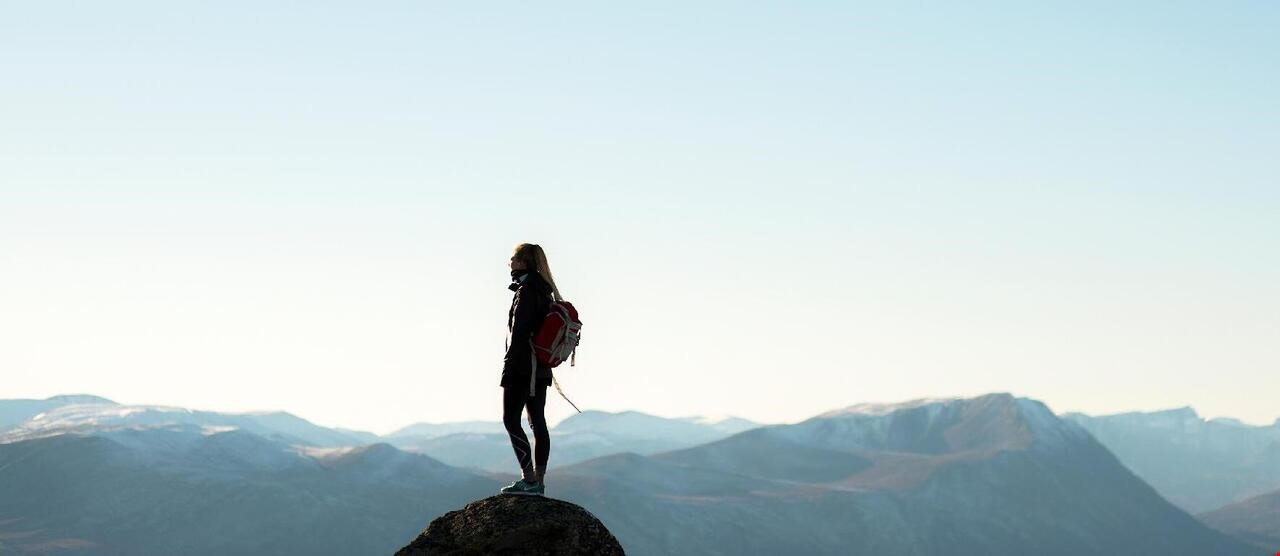 En dame som står på en fjelltopp