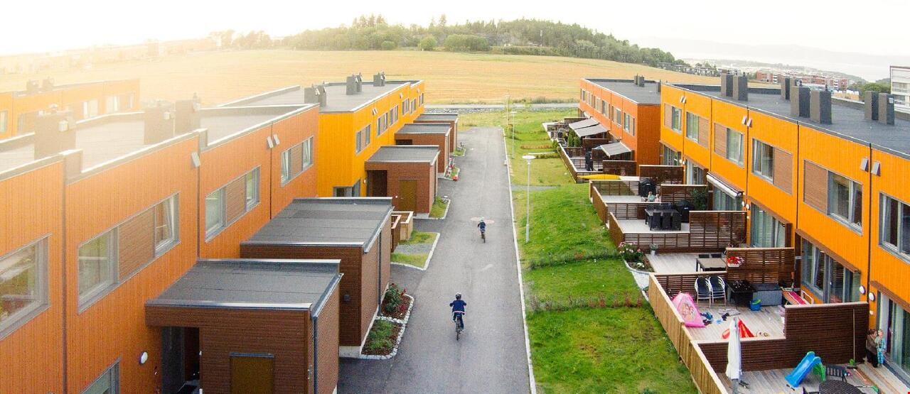 En rekke med moderne, oransje boliger sett fra fugleperspektiv