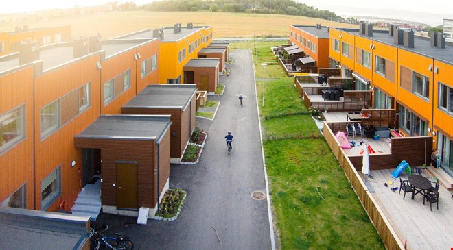 En rekke med moderne, oransje boliger sett fra fugleperspektiv