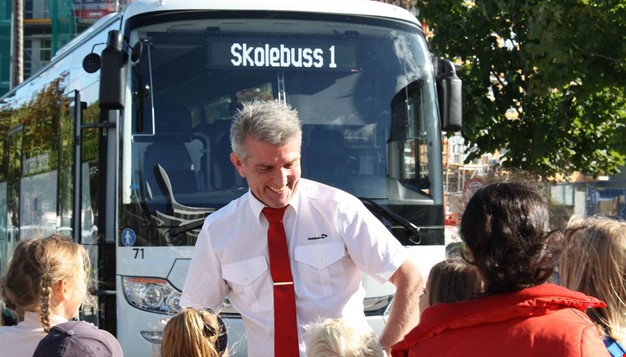 Bilde av en bussjåfør sammen med noen barn