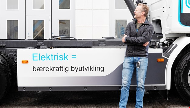 En mann står for foran en elektrisk lastebil med påskriften: Elektrisk = bærekraftig byutvikling