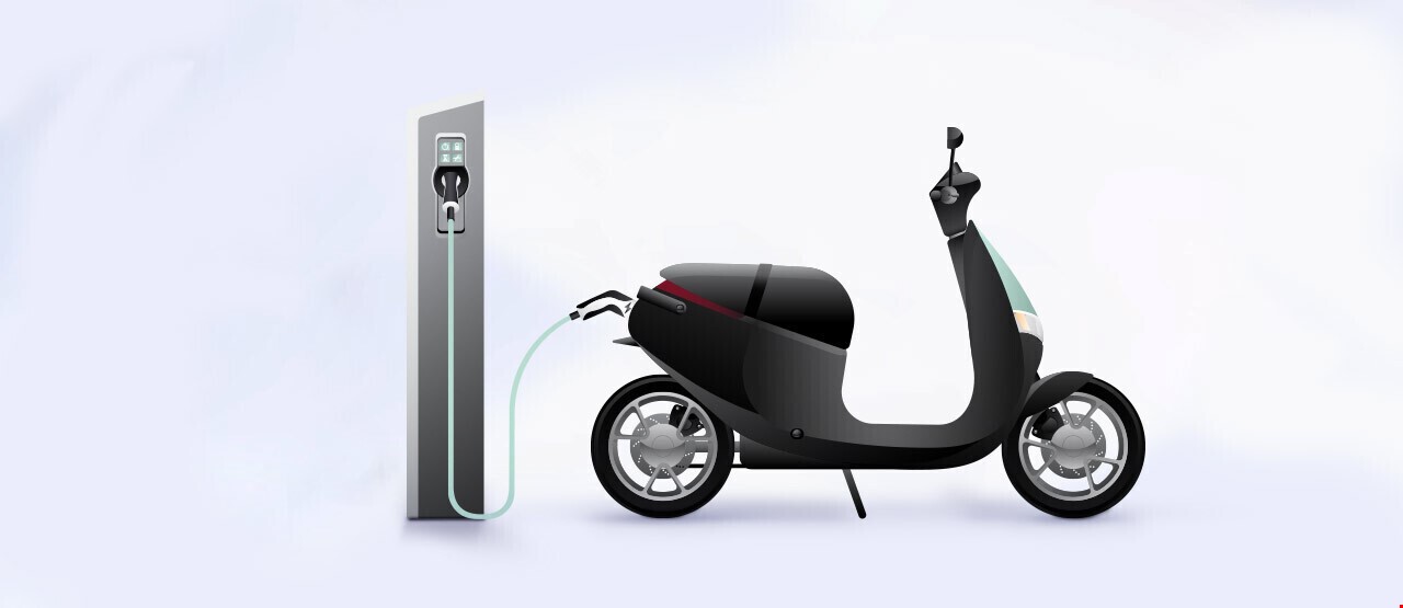 Scooter som lader på en ladestasjon