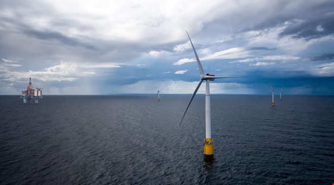 Vindmølle på sjøen med platform i bakgrunnen