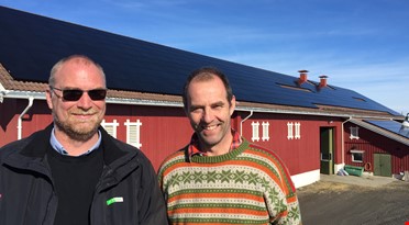 Foran driftsbygningen. Her ser du det meste av taket dekket med solceller. Fra venstre: Karl Andreassen, Hans Arild Grøndahl.