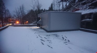 et hvitt rektangulært objekt med snø på bakken med fotspor
