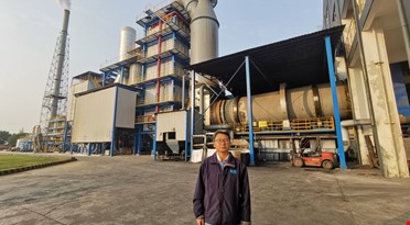 En mann som står foran en fabrikk