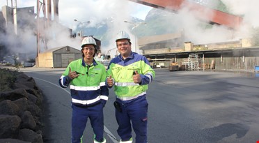 To blide arbeidere på utsiden av smelteverket. Foto: Kåre Frøystein