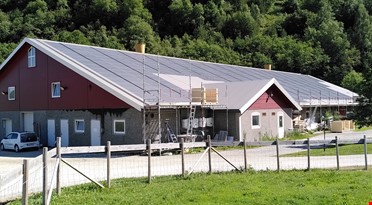 En bygning med stilas og solcellepanel
