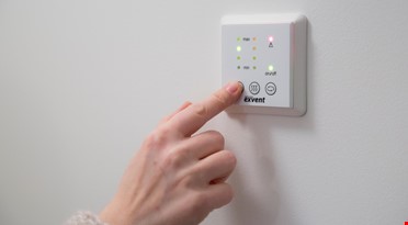 en person som trykker på en knapp på en vegg